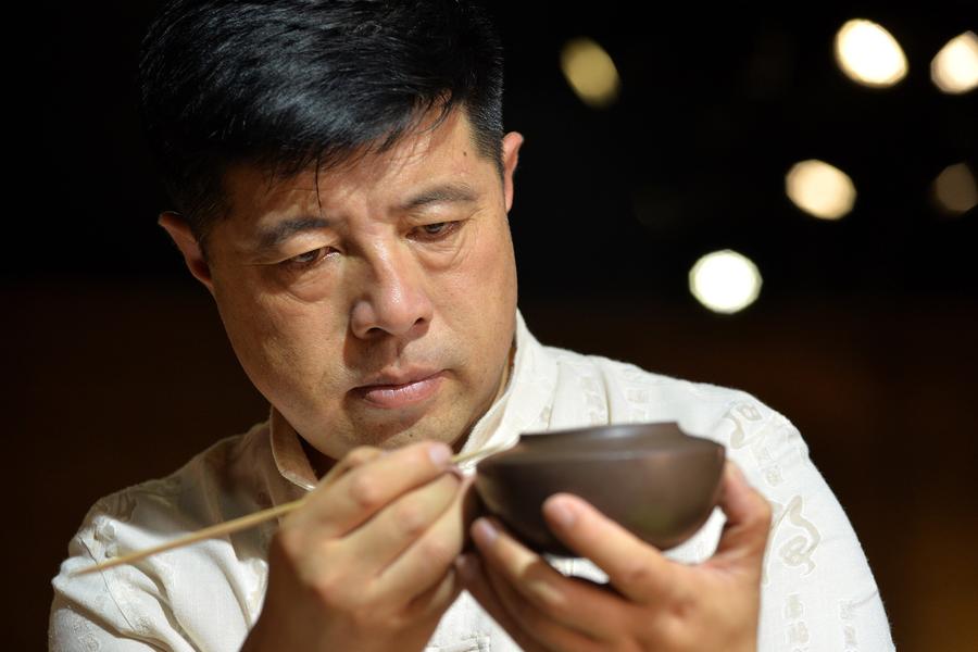 Bai Xuefeng trabaja en una pieza de cerámica de esmalte de color rojo oscuro en su taller en la ciudad de Chaoyang, provincia de Liaoning , 21 de julio.