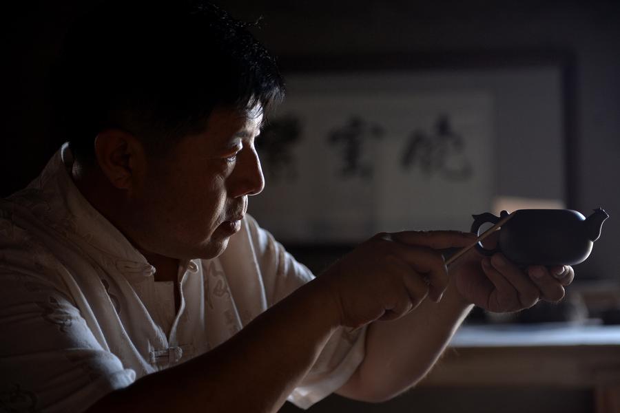 Bai Xuefeng trabaja en una pieza de cerámica de esmalte de color rojo oscuro en su taller en la ciudad de Chaoyang, provincia de Liaoning , 21 de julio.