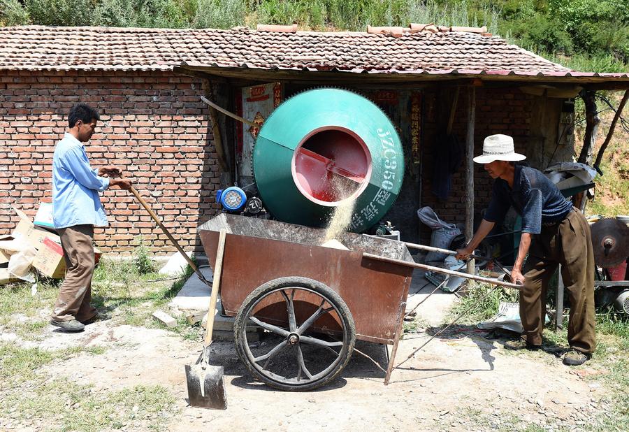 Zhang y su hijo preparan la comida para las crías de jabalí. Longhua, Hebei.