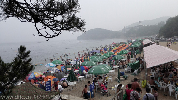 Ba?istas se divierten en una playa de Dalian, en la provincia de Liaoning. Los turistas siguen dispuestos a disfrutar de las playas, aunque el calor del veranose aleja y comienza el principio del oto?o. 17 de agosto de 2014. [Foto/IC] 