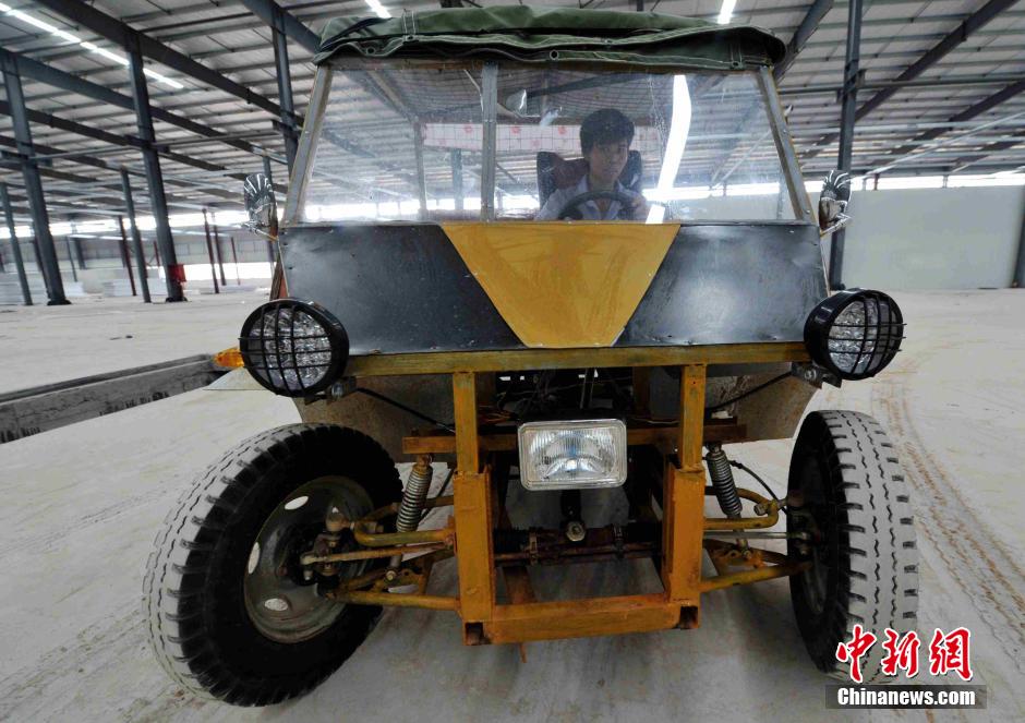 El joven inventor conduce su singular automóvil.