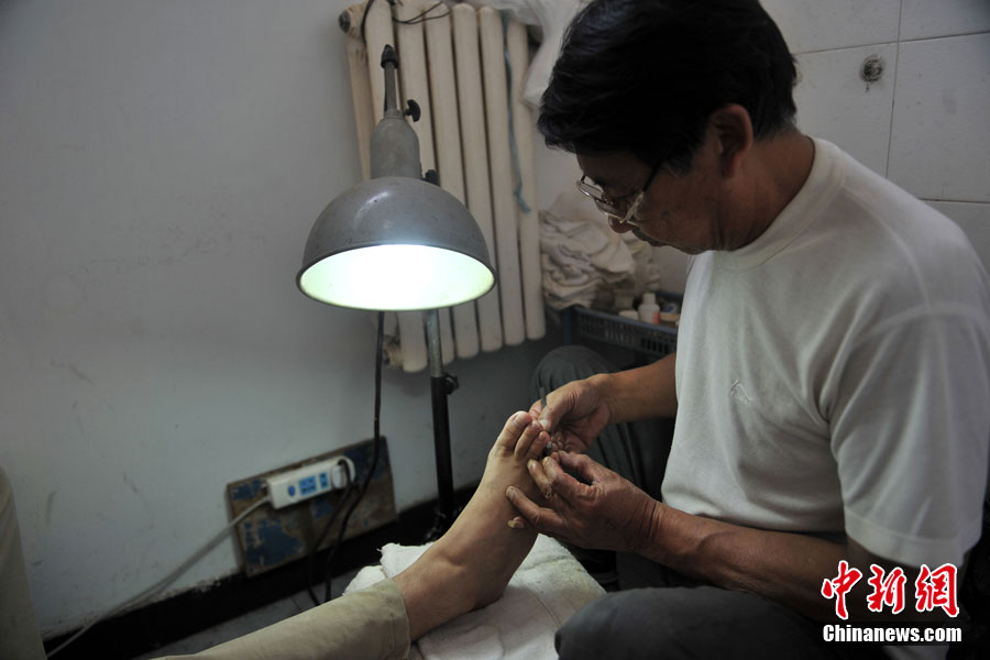 Zhang, que trabaja en el ba?o, ofrece una pedicura a un cliente.