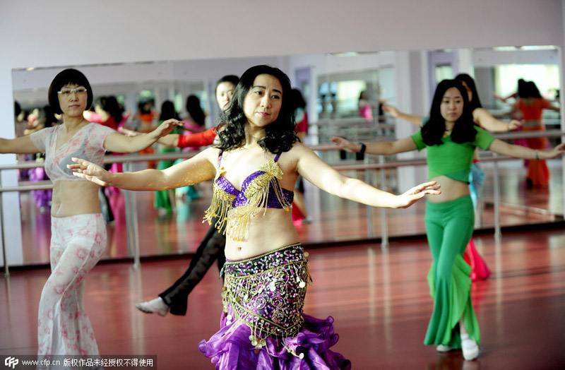 Mujeres aprenden danza del vientre para mantenerse en forma y aliviar el estrés en Shenyang, provincia de Liaoning, el 7 de diciembre de 2014. [Foto / PPC]