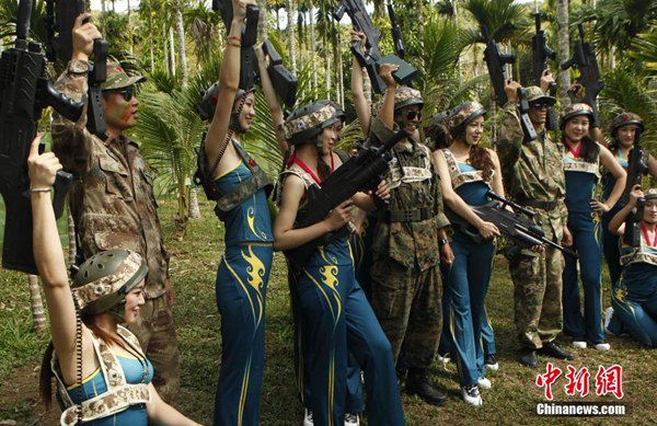 Las candidatas "Miss?Leisure?2014",?camuflajeadas?y?sosteniendo?armas?láser,?juegan?al Counter-Strike en Hainan. [Foto: Chinanews.com]