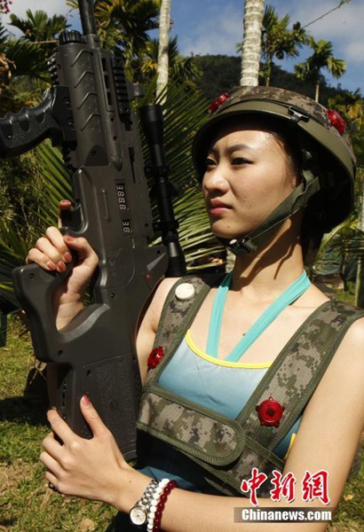 Las candidatas "Miss?Leisure?2014",?camuflajeadas?y?sosteniendo?armas?láser,?juegan?al Counter-Strike en Hainan. [Foto: Chinanews.com]