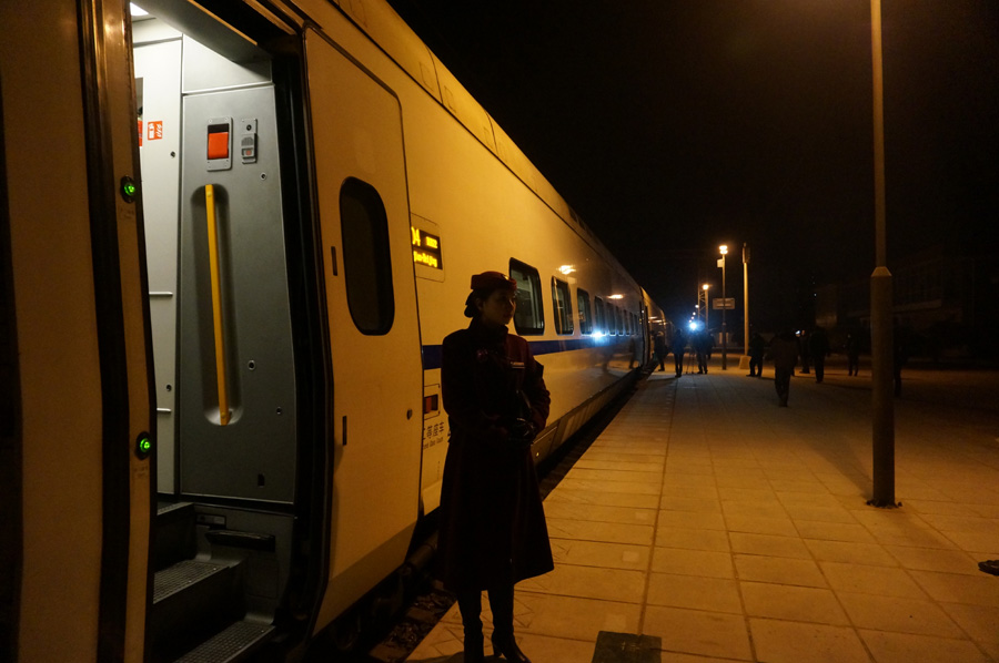 Una azafata del tren D9022 espera fuera el vagón en la estación de trenes de Yanjiao. El tren es el único de los tres trenes bala que sale por la ma?ana. [Fotografía de Zhang Xiang/chinadaily.com.cn]