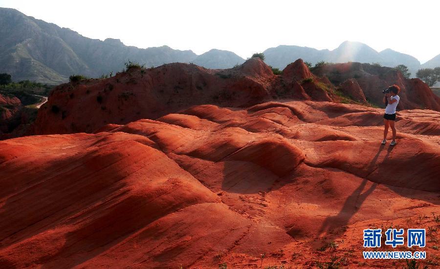 Un turista toma fotos en el punto de observación de Hongshimao en Jingbian, provincia de Shaanxi. en el Parque Geológico de Zhangye, en Gansu. (Foto: Song Wang)