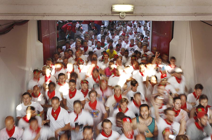 Los corredores entran en la plaza de toros durante el inicio de la fiesta de San Fermín en Pamplona, Espa?a, el 7 de julio de 2015. El festival, más conocido por las carreras diarias junto a los toros, arrancó el lunes con el lanzamiento del tradicional "Chupinazo" y durará hasta el 14 de julio. [Agencias de fotografía]