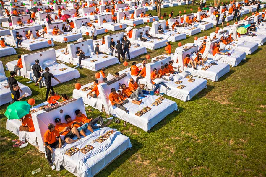  Guinness al mayor número de personas desayunando en la cama. El nuevo récord fue alcanzado cuando se dio por válido que 418 de los 490 participantes estaban desayunando simultáneamente en un espacio de cinco minutos. La prueba requería que los participantes no tocaran su comida antes del comienzo y permanecieran sentados contra el cabecero mientras comían. El récord anterior se consiguió en el Pudong Shangri-la de Shanghai, que acogió a 388 personas. [Foto chinadaily.com.cn]