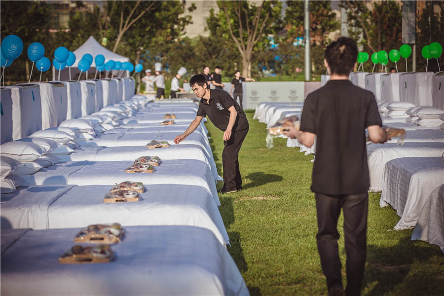 Trabajadores del hotel colocan los desayunos antes del evento. [Foto chinadaily.com.cn]