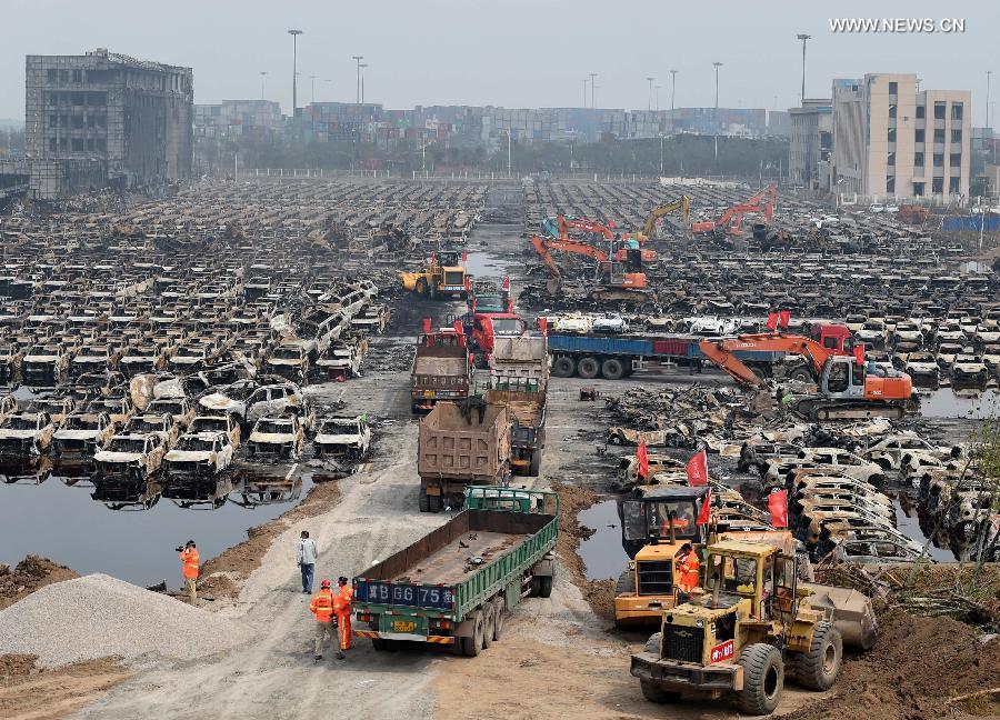 El servicio de rescate y varias máquinas retiran los vehículos calcinados tras la explosión de Tianjin, el 20 de agosto. [Foto/Xinhua]