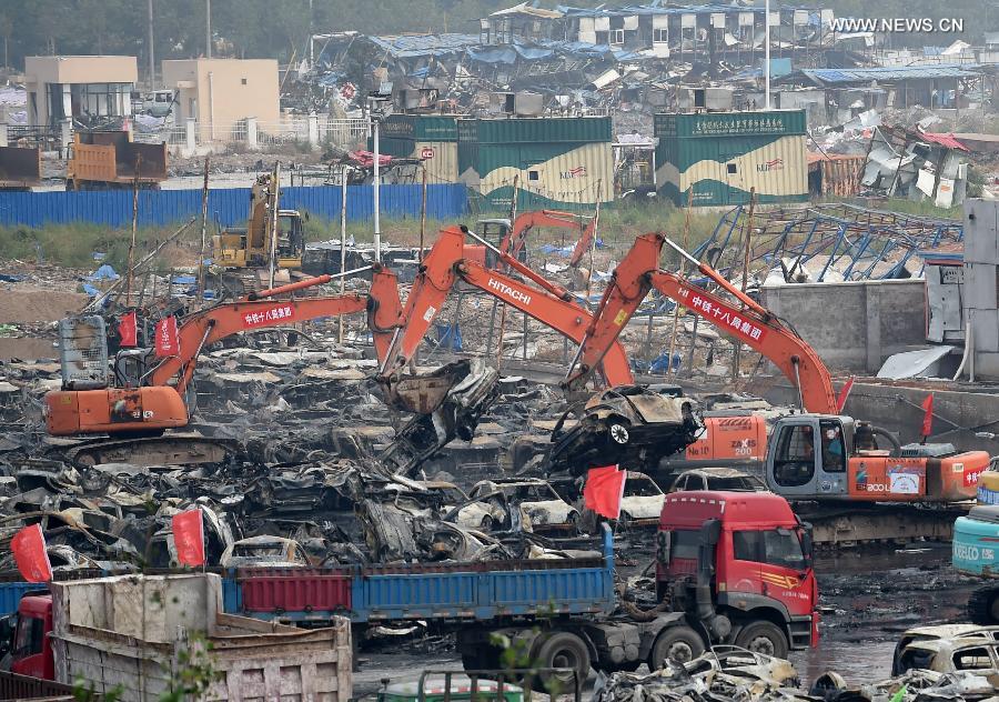 El servicio de rescate y varias máquinas retiran los vehículos calcinados tras la explosión de Tianjin, el 20 de agosto. [Foto/Xinhua]