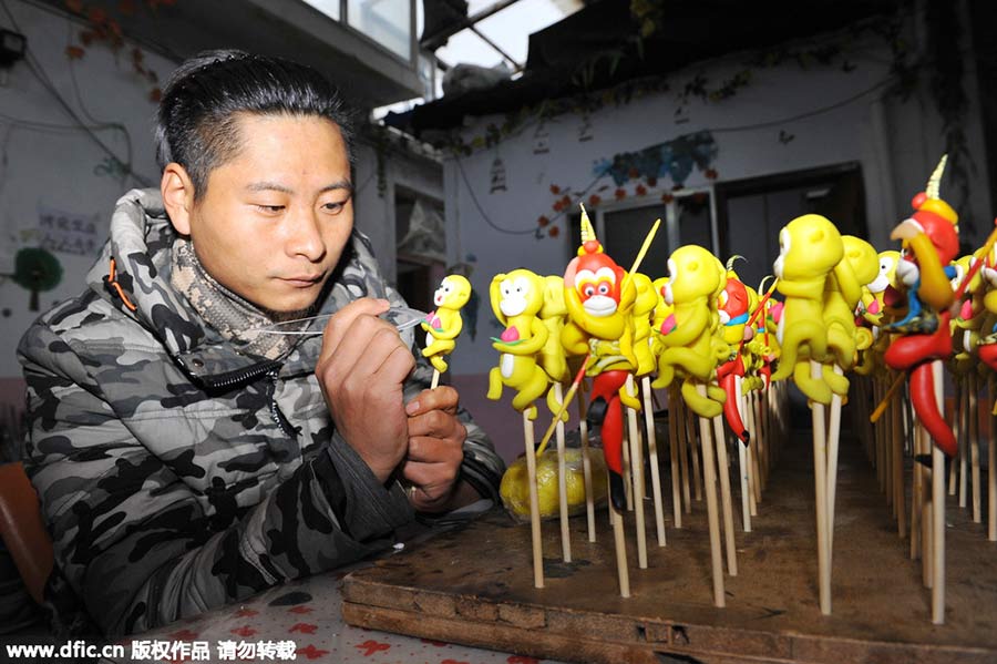 El artista Li Jinguo pinta las figuras de masa con forma de monos n Rizhao, provincia de Shandong. [Foto/IC]