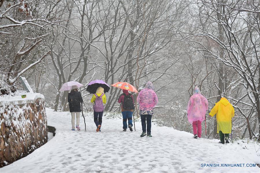 Gente escalan una monta?a en la nieve en Nanjing, capital de la provincia de Jiangsu, este de China, enero 22, 2016. La estación central Meteoical emitió alerta amarilla para el brote de aire frío viernes. (Xinhua / Wang Yuewu)