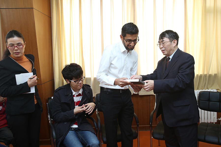 Nie Weiping entrega un regalo al presidente ejecutivo de Google, Sundar Pichai, el 31 de marzo de 2016. [Foto de China Daily]