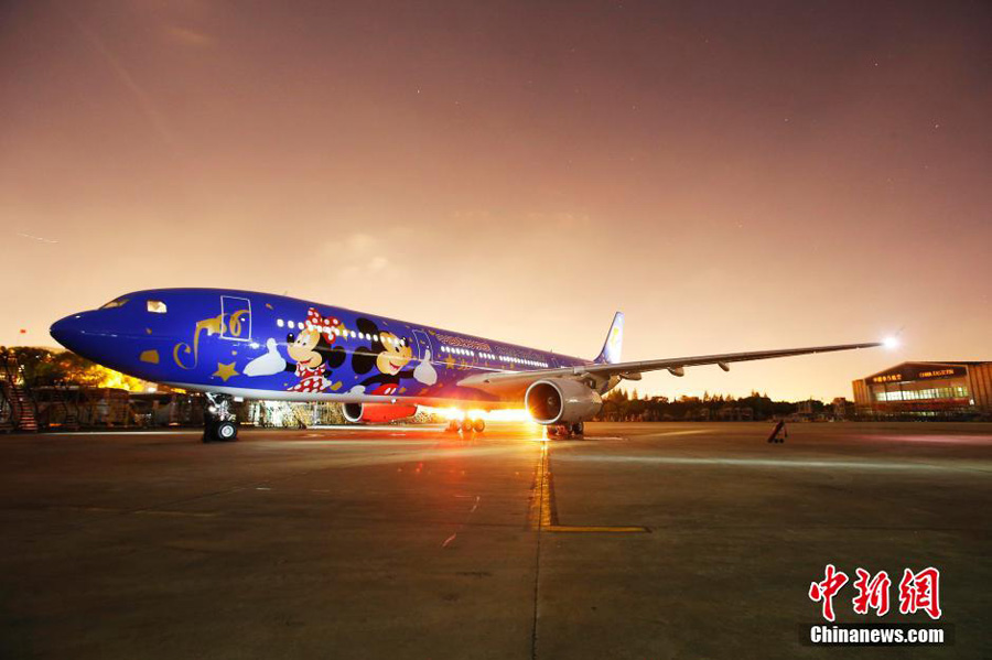 Un avión con temática de Shanghai Disney ha hecho su primera aparición en Shanghai el 25 de abril de 2016. El avión, operado por China Eastern Airlines, está pintado de azul con dos figuras gigantes de Mickey y Minnie Mouse. Más aviones con temática de Disney divertirán en un futuro próximo a los visitantes que lleguen a la ciudad. El parque temático Disneyland Shanghai abrirá sus puertas el 16 de junio. [Foto/Chinanews.com]