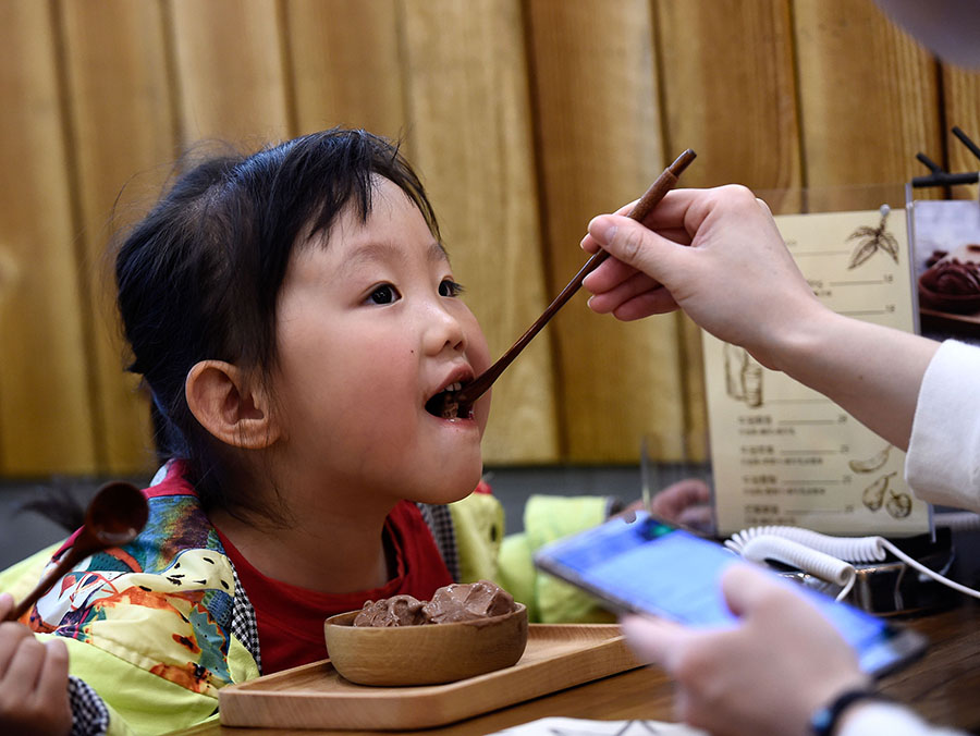 Una madre da a su hija peque?a un helado de la tienda de Cui en Taiyuan, provincia de Shanxi, el 26 de abril de 2016. [Foto/Xinhua]