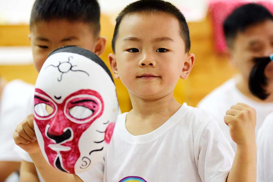 Un ni?o muestra la máscara facial que hizo de los personajes de la ópera de Pekín en la ciudad de Hefei, provincia de Anhui, el 3 de junio de 2016. [Foto de Ge Yinian/Asianewsphoto]