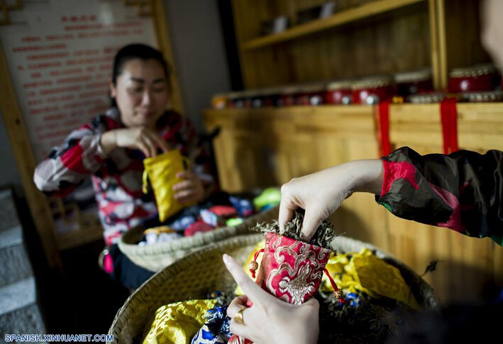 Personas elaboran bolsas con hierbas perfumadas, para marcar el próximo Festival del Bote del Dragón, en el condado Zigui, capital de la provincia central de Hubei, China, el 8 de junio de 2016. El Festival del Bote de Dragón o "Duanwu" en chino, se celebra el quinto día del quinto mes del calendario lunar, celebrándose este a?o el 9 de junio. (Xinhua/Xiao Yijiu)  