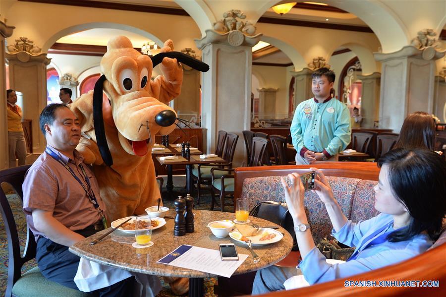 Un visitante posa con empleados vestidos como personajes de Disney en el Shanghai Disneyland Hotel en Shanghai, en el este de China, el 14 de junio de 2016. El Shanghai Disney Resort, el sexto en el mundo, abrirá oficialmente el 16 de junio. (Xinhua/Liu Xiaojing)