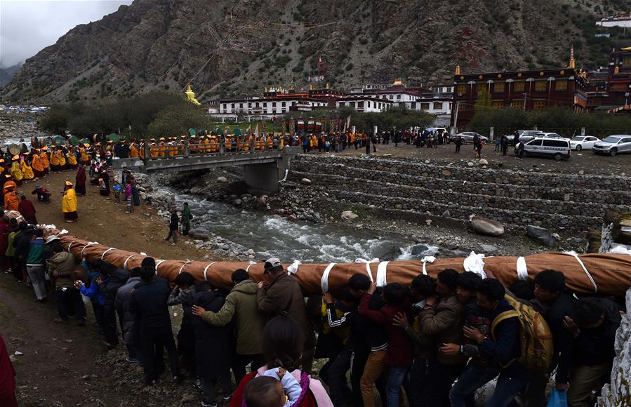 Seguidores del budismo asisten a una actividad de adoración de Thangka, en el Monasterio Tsurphu en Lhasa, capital de la región autónoma del Tíbet, en el suroeste de China, el 16 de junio de 2016.Una actividad anual de adoración Thangka para mostrar un Thangka de 38 por 35 metros fue llevada a cabo el jueves en el Templo Tsurphu, una base importante de la escuela Kagyu en el budismo tibetano. La Thangka es una bandera budista tibetana de seda pintada o bordada. (Xinhua/Chogo)