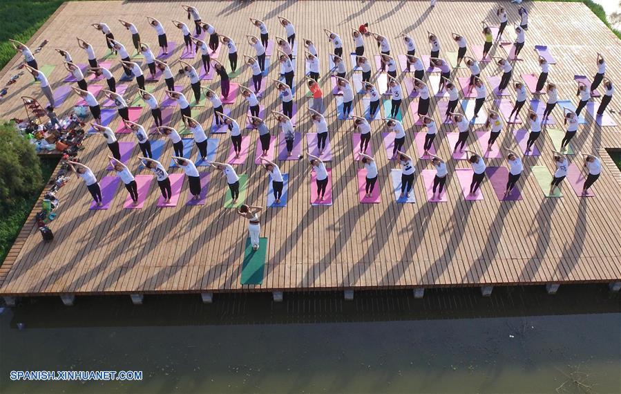 Henan: Personas practican yoga en el Parque Lago Longquan en Jiaozuo