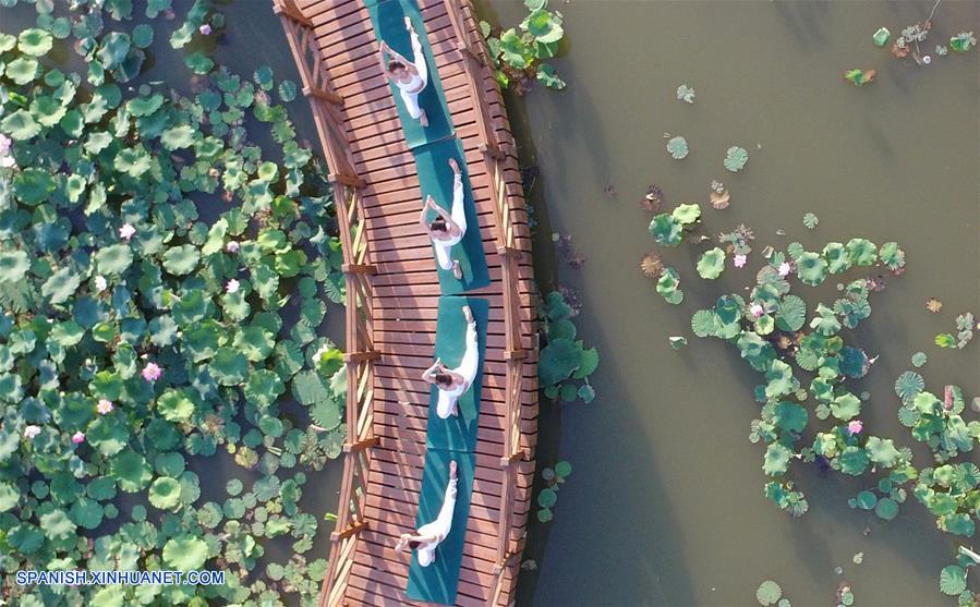 Henan: Personas practican yoga en el Parque Lago Longquan en Jiaozuo