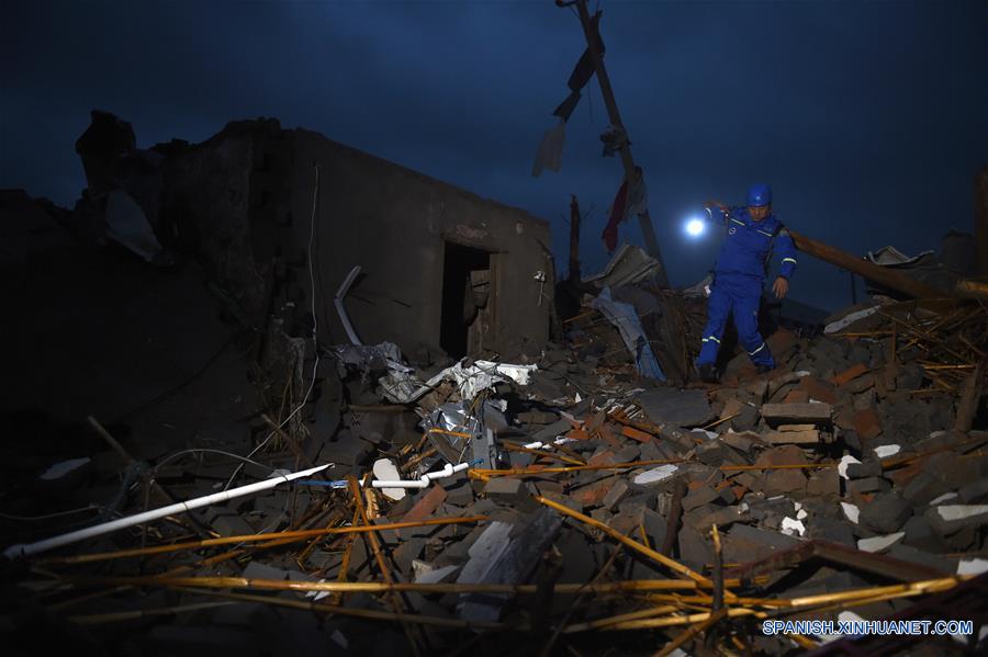 Un rescatista busca sobrevivientes en la aldea Beichen del condado de Funing, ciudad de Yancheng, en la provincia de Jiangsu, en el este de China, el 24 de junio de 2016. Al menos 78 personas murieron, mientras que cerca de 500 personas resultaron heridas, en uno de los desastres naturales más letales registrados en décadas en la provincia oriental china de Jiangsu. Aguaceros, granizadas y el peor tornado desde 1966 azotaron parte de la ciudad de Yancheng a las 14:30 hora local del jueves, destruyeron viviendas y dejaron atrapados a cientos de residentes del lugar bajo los escombros. (Xinhua/Han Yuqing)