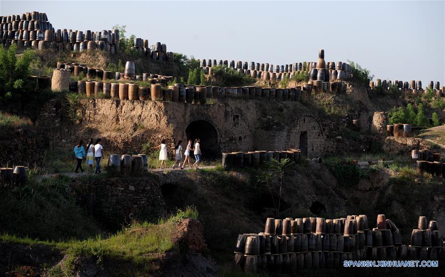 Estudiantes visitan la zona turística de Yaotou Kiln en el municipio de Yaotou del condado de Chengcheng, provincia de Shaanxi, en el noroeste de China, el 29 de junio de 2016. El sitio de antiguos hornos populares, cubriendo un área de cuatro kilómetros cuadrados, tiene una historia de elaboración de productos de cerámica de más de mil a?os. La técnica de elaboración de cerámica en Yaotou Kiln fue incluida en el Patrimonio Nacional Cultural Intangible en el 2006. (Xinhua/Tao Ming)  