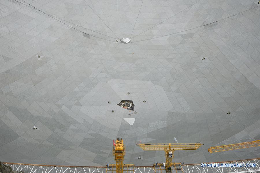 El último panel triangular del reflector del Telescopio de Apertura Esférica de 500 metros, o "FAST", es colocado en el condado de Pingtang, provincia de Guizhou, en el suroeste de China, el 3 de julio de 2016. La instalación del "FAST", el radiotelescopio más grande del mundo, fue completada el domingo por la ma?ana al colocar el último de los 4,4450 paneles en el centro del gran plato. Los científicos comenzarán las pruebas de depuración y observación del FAST. (Xinhua/Liu Xu)