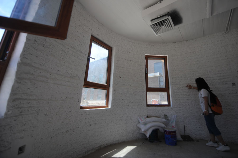 Una mujer toca un muro en el interior de la primera casa construida con impresión 3D en el distrito Tongzhou de Beijing, el 1 de julio de 2016. 