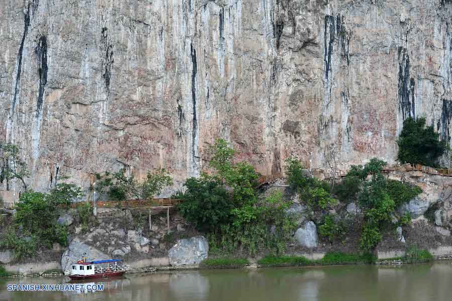 GUANGXI, julio 15, 2016 (Xinhua) -- Vista de las pinturas rupestres sobre la Monta?a Huashan por el río Zuojiang en el condado de Ningming, en la Región Autónoma Zhuang de Guangxi, en el sur de China, el 15 de julio de 2016. El Paisaje Cultural de Arte Rupestre de Zuojiang de Guangxi fue a?adido este viernes a la lista del Patrimonio Mundial en la 40 sesión del Comité del Patrimonio Mundial llevada a cabo en Estambul. Las pinturas rupestres que se componen de más de 1,900 dibujos que representan los tambores y elementos relacionados con registros simbólicos asociados directamente con la cultura del tambor de bronce del pueblo Luoyue alguna vez generalizadas en la región hace más de 2,000 a?os. (Xinhua/Zhou Hua)