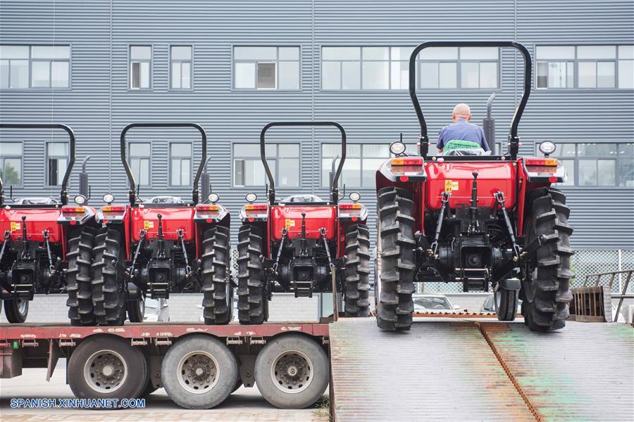  Imagen del 16 de agosto de 2016 de un trabajador conduciendo un tractor "Dongfanghong" al interior de un camión, en Luoyang, provincia de Henan, en el centro de China.