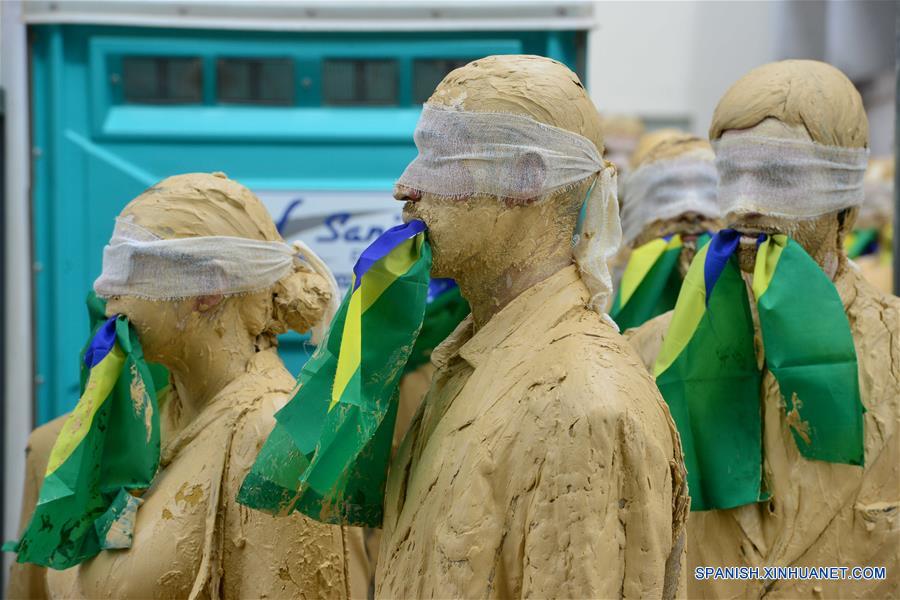 Actores cubiertos de lodo participan durante una manifestación silenciosa en favor de la democracia en la ciudad de Sao José dos Campos, estado de Sao Paulo, Brasil, el 3 de septiembre de 2016. De acuerdo con información de la prensa local, un grupo de actores de teatro procedentes del 31 Festival de Teatro protagonizaron la manifestación.