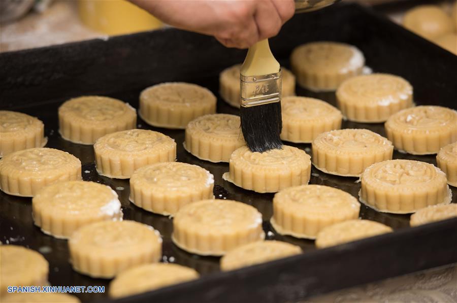  Un repostero pasa una brocha con una mezcla de huevo a las tartas de luna en un restaurante chino, en El Cairo, Egipto, el 14 de septiembre de 2016. La tarta de luna es un producto de pastelería tradicional chino consumido durante el Festival de Medio Oto?o, que cae el día 15 del noveno mes del calendario lunar. (Xinhua/Meng Tao)