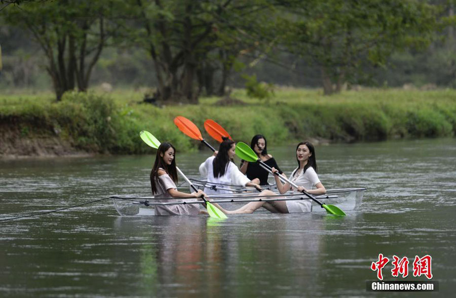 Turistas reman en botes transparentes en Hunan