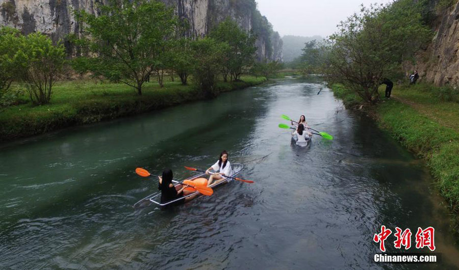 Turistas reman en botes transparentes en Hunan