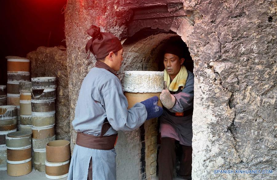 Miembros del personal sacan un recipiente durante una ceremonia de retiro de porcelanas del horno, en el municipio de Shenhou de la ciudad de Yuzhou, provincia de Henan, en el centro de China, el 19 de noviembre de 2016. La porcelana Jun es famosa por su asobroso cambio de color durante el proceso de fundido en hornos. Shenhou, una localidad antigua ubicada en la zona monta?osa de Henan, tiene una larga historia de elaboración de porcelana Jun. (Xinhua/Li An)