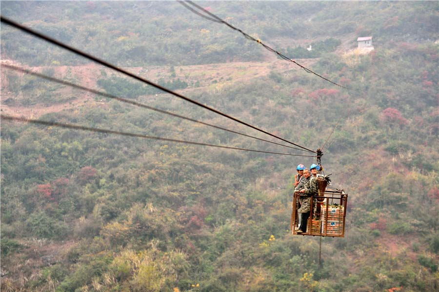 Naranjas transportadas en el teleférico. [Foto de Liu Shusong / para chinadaily.com.cn]