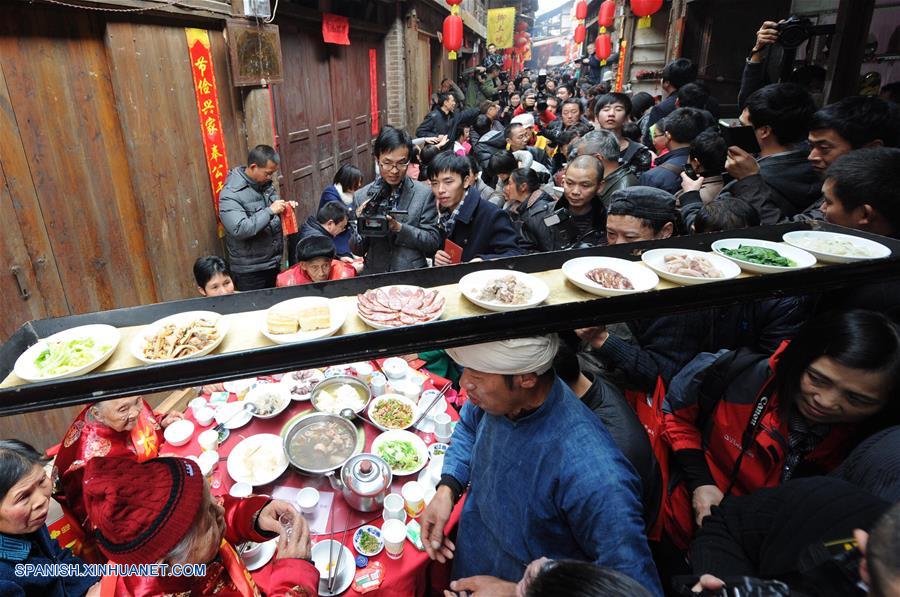 Imagen del 7 de febrero de 2013, de un hombre cargando en la cabeza una bandeja con platos durante un banquete tradicional por el A?o Nuevo Lunar chino en el municipio de Zhongshan de la municipalidad de Chongqing, en el suroeste de China. El espíritu más importante del A?o Nuevo Lunar chino, o Festival de Primavera, es la reunión familiar. Es también la mejor época para que las personas de todas las edades se reúnan a disfrutar de una deliciosa comida. (Xinhua/Li Jian)