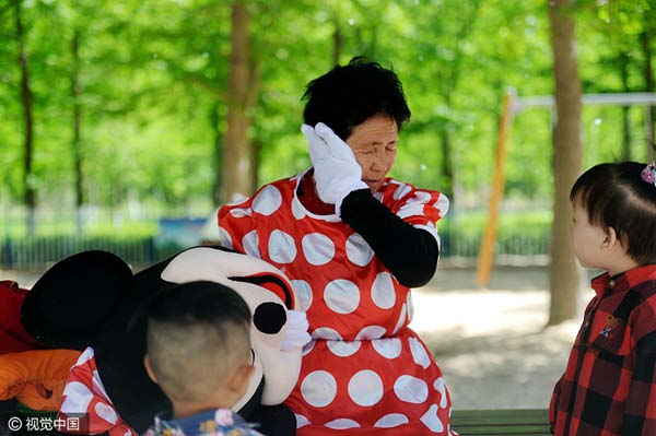 Yin Pizhi se seca el sudor durante su trabajo en un parque en Jinan, provincia de Shandong, el 18 de abril de 2016. [Foto / VCG]