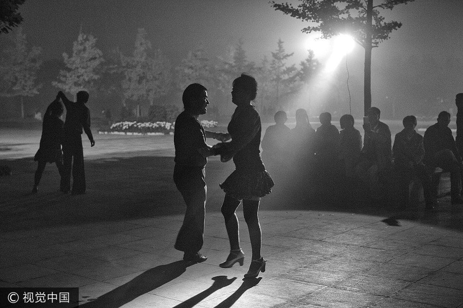 La gente baila en un día con niebla, en Beijing, el 19 de octubre de 2016. [Foto / VCG]