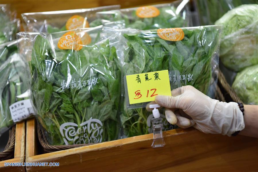 HONG KONG, junio 18, 2017 (Xinhua) -- Imagen del 17 de junio de 2017, de un vendedor preparando la etiqueta con el precio para amaranto comestible empacado en una tienda, en Hong Kong, en el sur de China. Según las estadísticas de las autoridades locales, más del 85 por ciento de los vegetales, frutas y aves de corral vivas que llegaron desde la parte continental de China a los mercados de Hong Kong, fueron transportados a través del puerto Wenjindu de Shenzhen. (Xinhua/Lui Siu Wai)