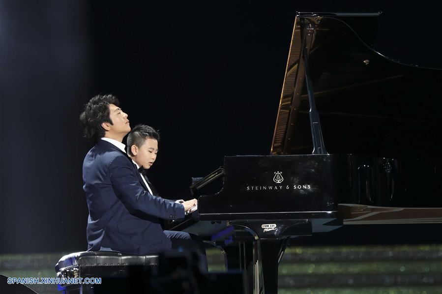 El pianista Lang Lang, interpreta una melodía junto a un ni?o durante una gala de noche llevada a cabo en celebración del 20 aniversario del retorno de Hong Kong a la patria, en Hong Kong, en el sur de China, el 30 de junio de 2017. (Xinhua/Ding Lin)