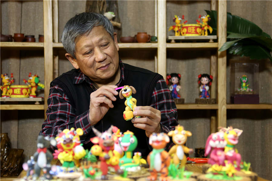 Kan Zongqin, escultor y heredero del arte popular tradicional, crea una escultura de masa que representa a un perro del zodiaco chino golpeando un tambor. Ciudad de Zaozhuang, provincia de Shandong, 24 de diciembre del 2017. [Foto: Ji Zhe]