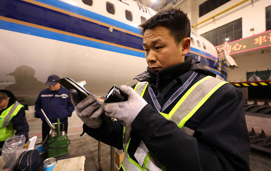 Un ingeniero limpia partes de aeronaves en un centro de mantenimiento en la ciudad de Wuhan que trabaja para la aerolínea China Southern, provincia de Hubei, 9 de febrero del 2018. [Foto: VCG]