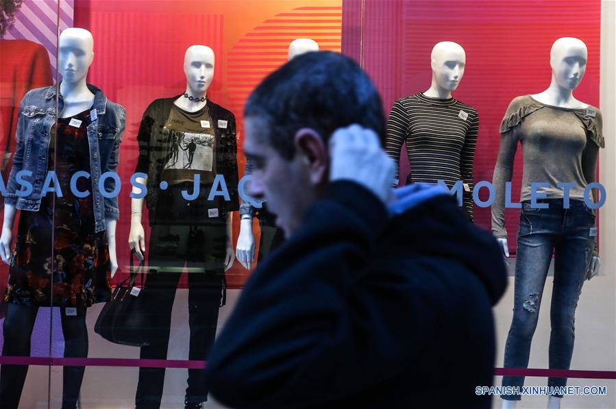 Un transeúnte camina frente a la vitrina de una tienda de ropa, en Sao Paulo, Brasil, el 8 de junio de 2018. La tasa de inflación de Brasil se situó en un 0.4 por ciento en mayo pasado y estuvo por arriba de la tasa registrada en abril (0.22 por ciento), informó el viernes el Instituto Brasile?o de Geografía y Estadística (IBGE). El IBGE atribuyó el resultado de mayo al paro protagonizado por miles de camioneros durante 11 días hasta finales del mes pasado que paralizó el país sudamericano. En los primeros cinco meses del a?o, Brasil registró una inflación de 1.33 por ciento, el menor resultado para el período desde 1994. (Xinhua/Rahel Patrasso)