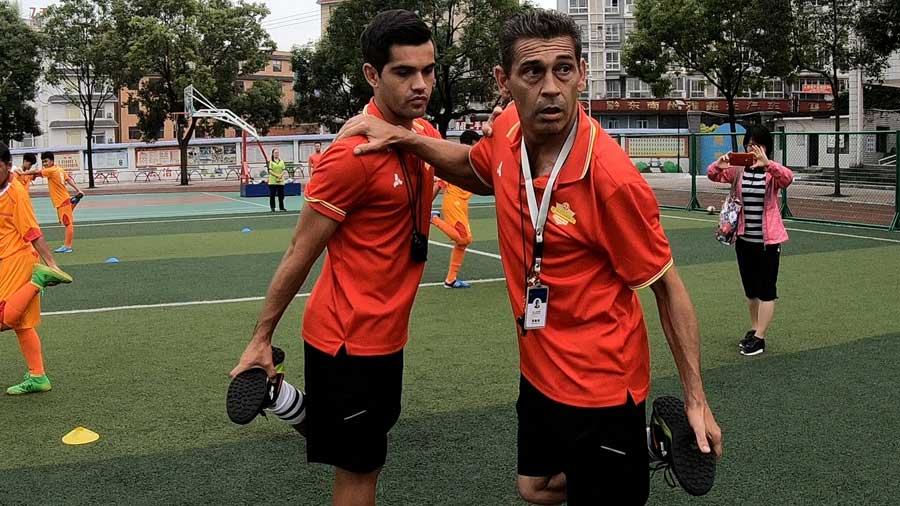 El entrenador espa?ol José (derecha) y el chileno Piri estrenan a ni?os chinos en la escuela Zhenghua en la ciudad de Kaili, suroeste de China.