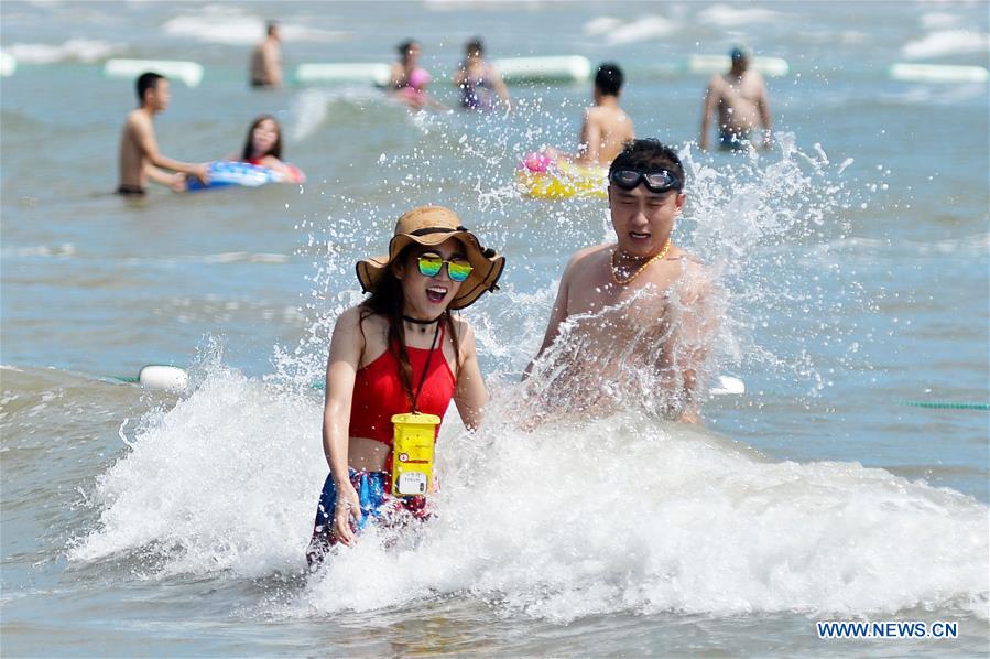 La gente juega en el balneario de Qingdao, E Shandong de China