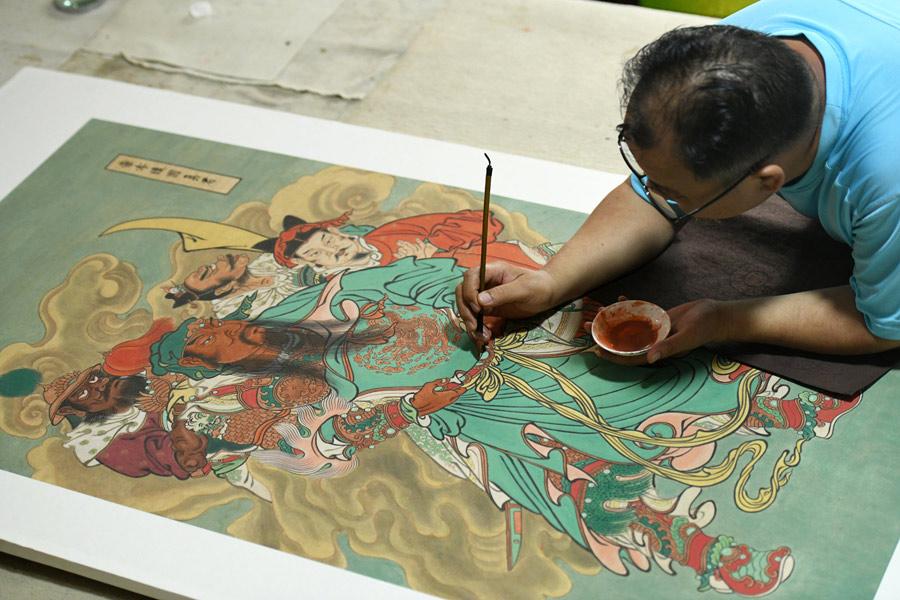 En su estudio, Yao Shulong dibuja una pintura china tradicional de a?o nuevo usando técnicas murales, 24 de julio del 2018. (Foto: Xinhua)